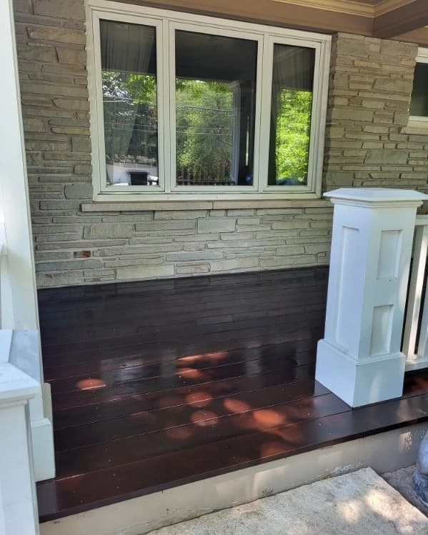 Stone walkway and porch steps beside a stained porch